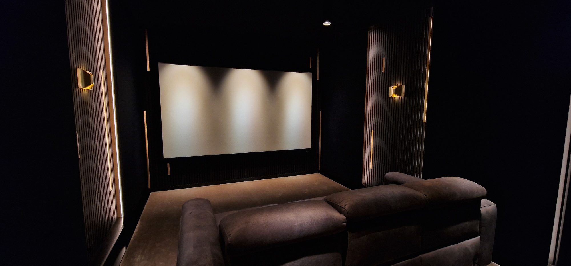Award-winning dedicated cinema room in Bath, converted from a garage — front wall with acoustic treatment visible.